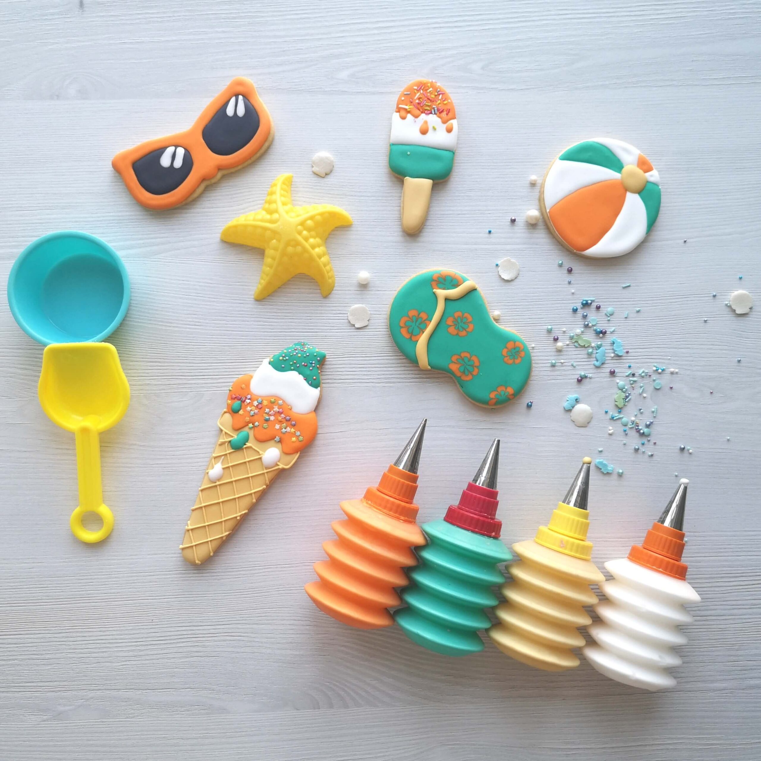 Summer Fun biscuits with royal icing including sunglasses, beach ball, lollipop, ice cream and flip flop